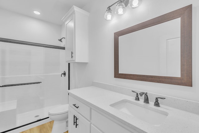 bathroom featuring vanity, toilet, hardwood / wood-style floors, and an enclosed shower