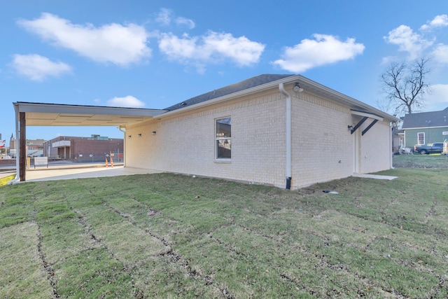 rear view of house with a carport and a yard