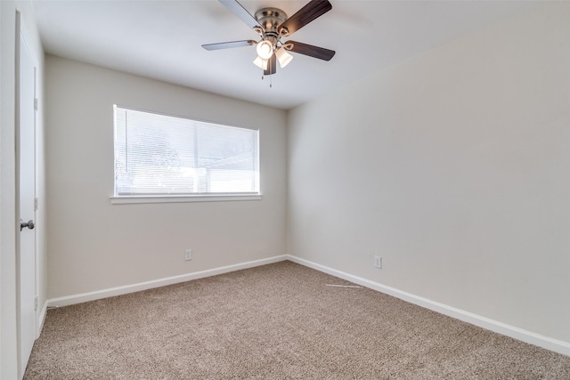 carpeted spare room featuring ceiling fan