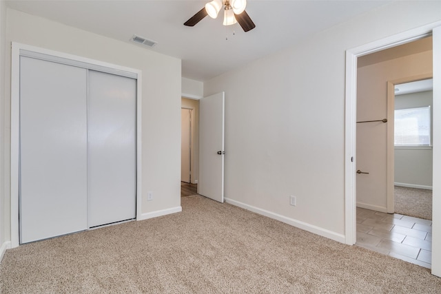 unfurnished bedroom with a closet, ceiling fan, and light colored carpet