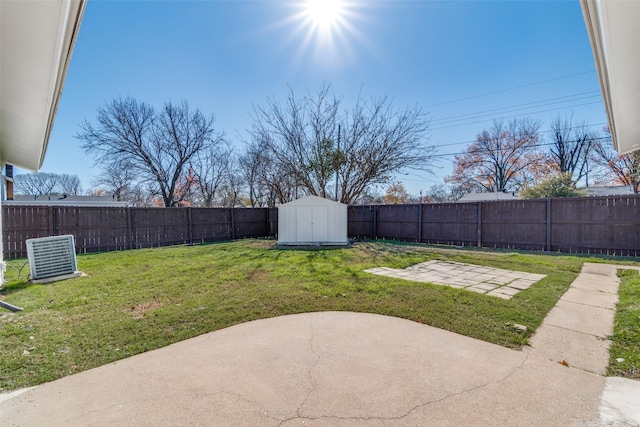 view of yard with a patio area, central AC, and a shed