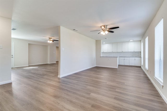 unfurnished living room featuring ceiling fan and light hardwood / wood-style flooring