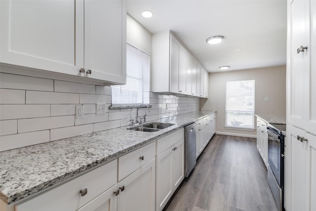 kitchen featuring sink, white cabinetry, light stone countertops, and appliances with stainless steel finishes