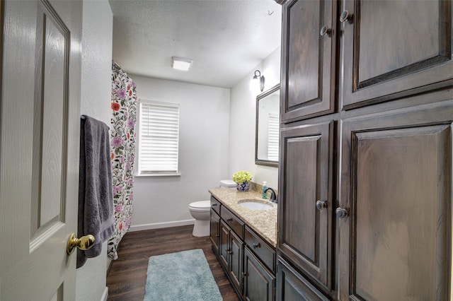 bathroom with hardwood / wood-style flooring, vanity, toilet, and walk in shower