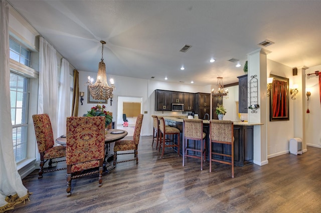 dining space with a notable chandelier and dark hardwood / wood-style floors