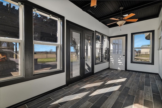 unfurnished sunroom with ceiling fan