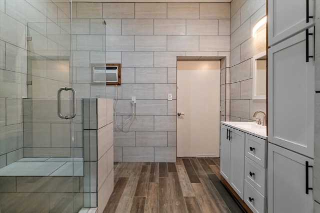 bathroom with an AC wall unit, walk in shower, and vanity