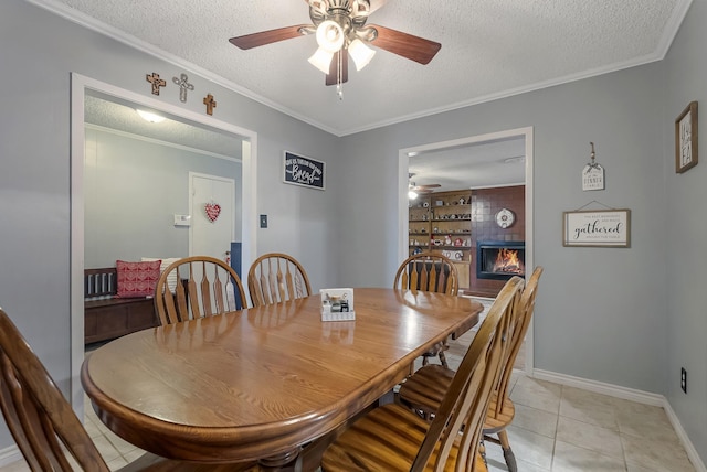 tiled dining area with ornamental molding, a tile fireplace, and a textured ceiling