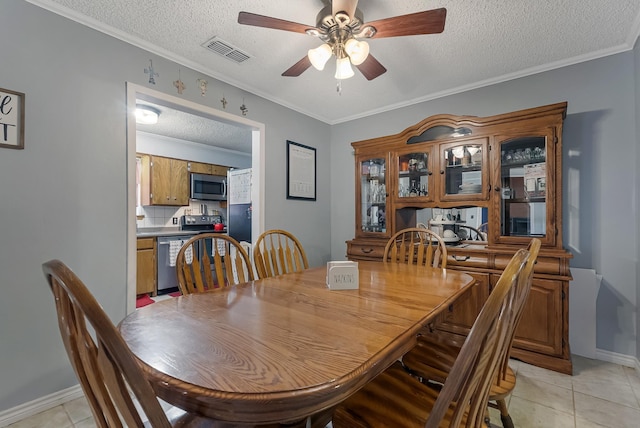 dining area with light tile patterned flooring, a textured ceiling, ceiling fan, and ornamental molding