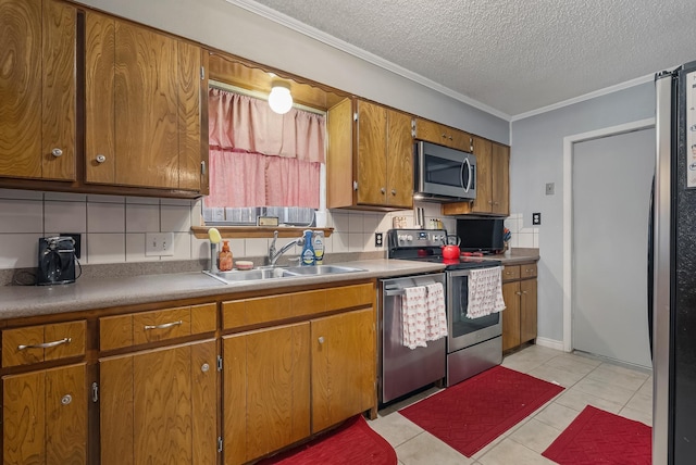 kitchen with crown molding, sink, tasteful backsplash, a textured ceiling, and stainless steel appliances