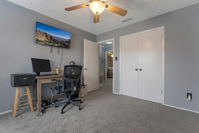 office area with ceiling fan, carpet flooring, and a textured ceiling