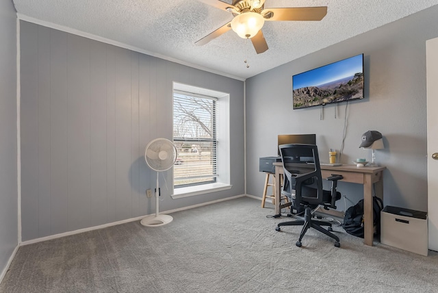 home office with carpet floors, a textured ceiling, wood walls, and ceiling fan