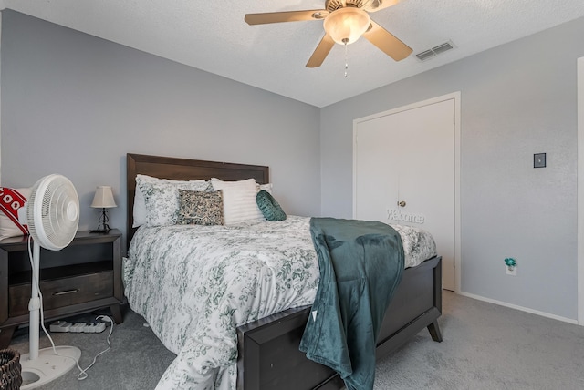 bedroom with a textured ceiling, carpet flooring, and ceiling fan