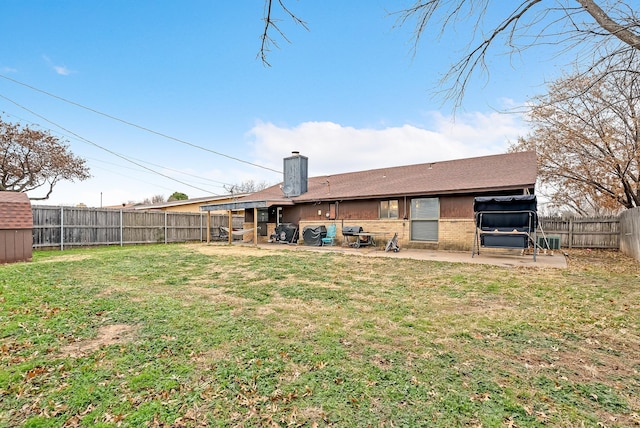 rear view of house with a patio and a lawn