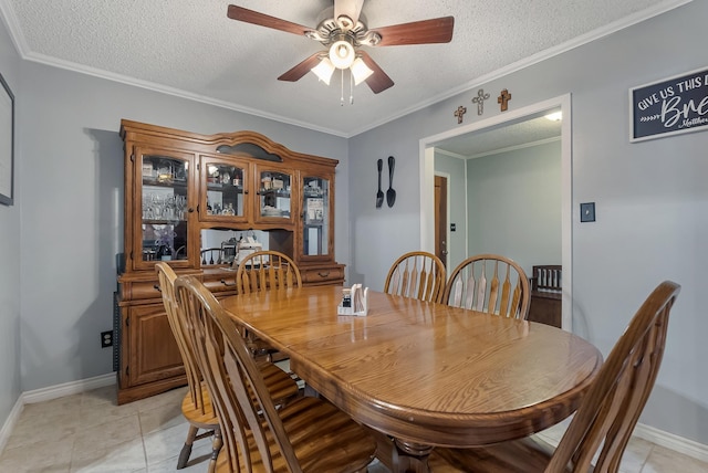 dining area with ceiling fan, a textured ceiling, light tile patterned floors, and ornamental molding