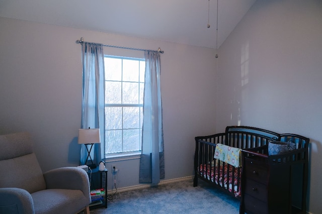 carpeted bedroom with a crib and lofted ceiling