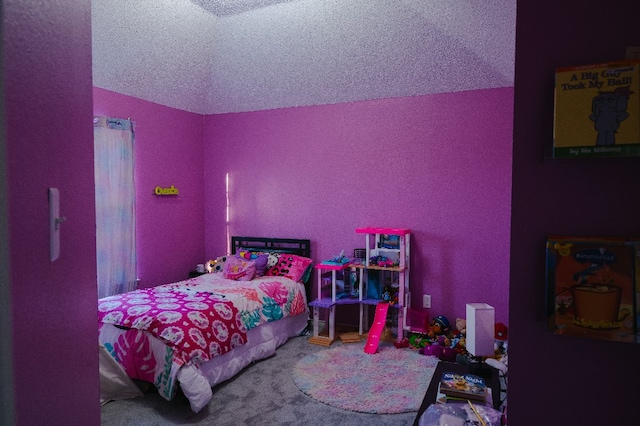 bedroom with vaulted ceiling, a textured ceiling, and carpet floors