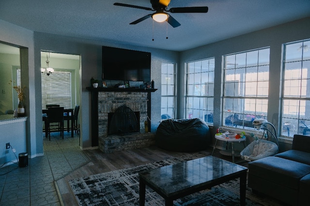 living room featuring a fireplace, ceiling fan, and a healthy amount of sunlight