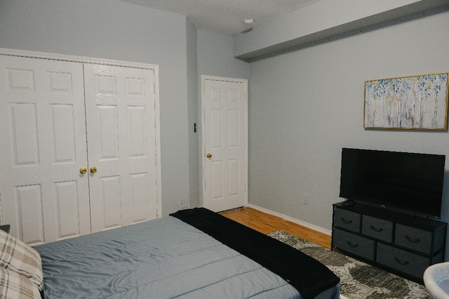 bedroom with hardwood / wood-style floors and a closet