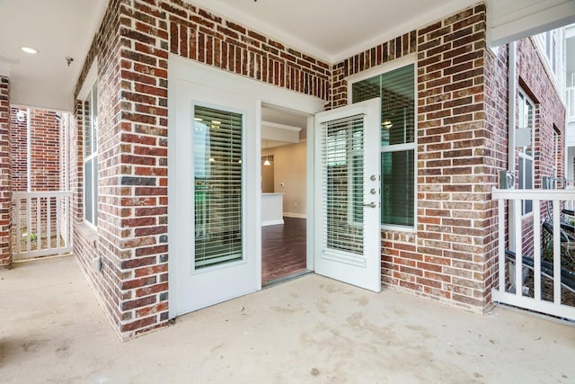 view of exterior entry with a patio area