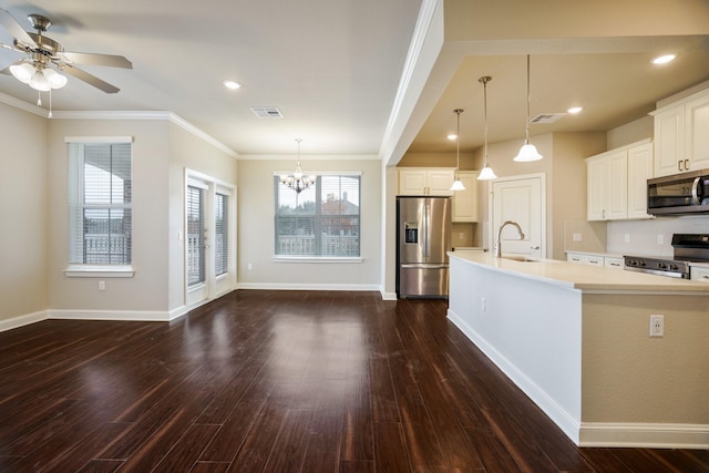 kitchen with sink, hanging light fixtures, appliances with stainless steel finishes, and a spacious island