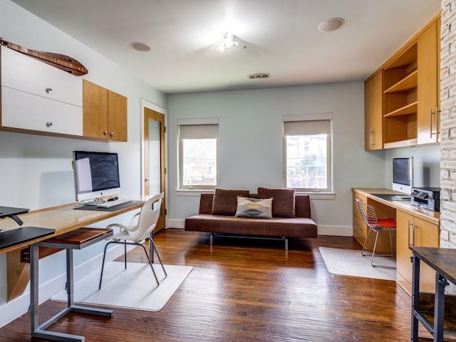 home office featuring dark wood-type flooring and built in desk