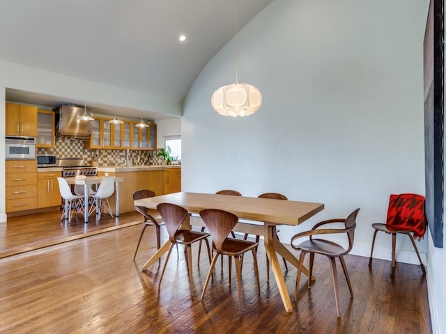 dining space featuring hardwood / wood-style flooring and lofted ceiling