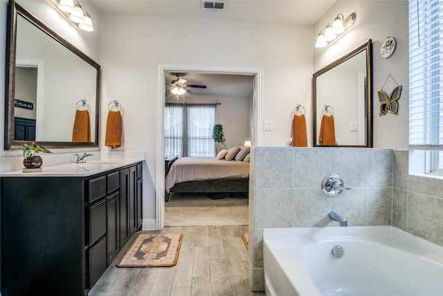 bathroom featuring ceiling fan, a bathtub, and vanity