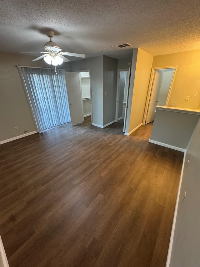 spare room with ceiling fan, dark wood-type flooring, and a textured ceiling