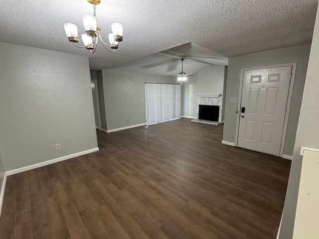 unfurnished living room with ceiling fan with notable chandelier, a textured ceiling, vaulted ceiling, and dark hardwood / wood-style flooring