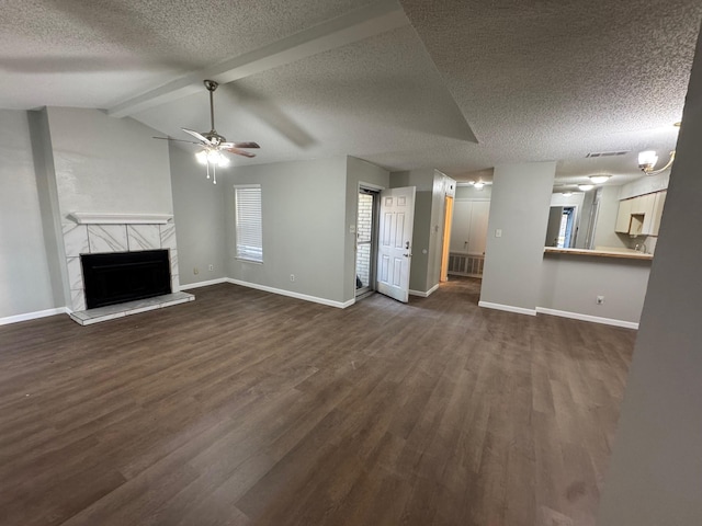 unfurnished living room featuring a tiled fireplace, a textured ceiling, dark hardwood / wood-style floors, and vaulted ceiling