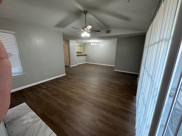 empty room featuring ceiling fan, dark hardwood / wood-style floors, a textured ceiling, and lofted ceiling with beams