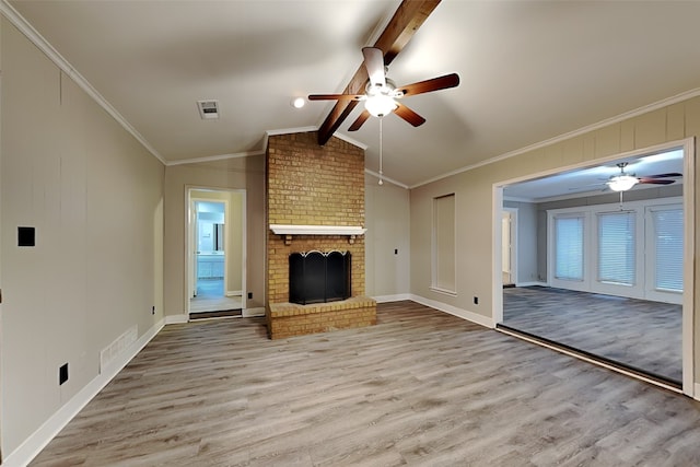 unfurnished living room with a fireplace, light wood-type flooring, lofted ceiling with beams, and crown molding