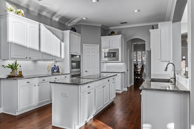 kitchen featuring dark hardwood / wood-style flooring, sink, backsplash, white cabinets, and stainless steel appliances