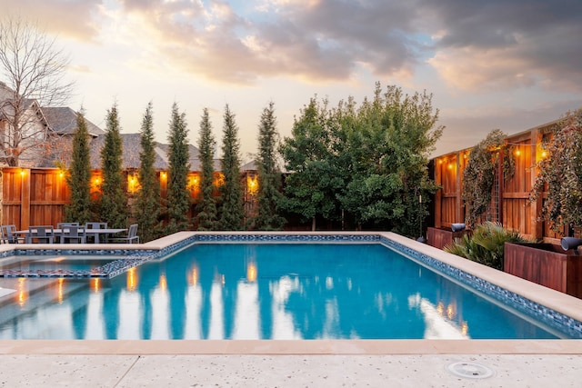 view of pool at dusk