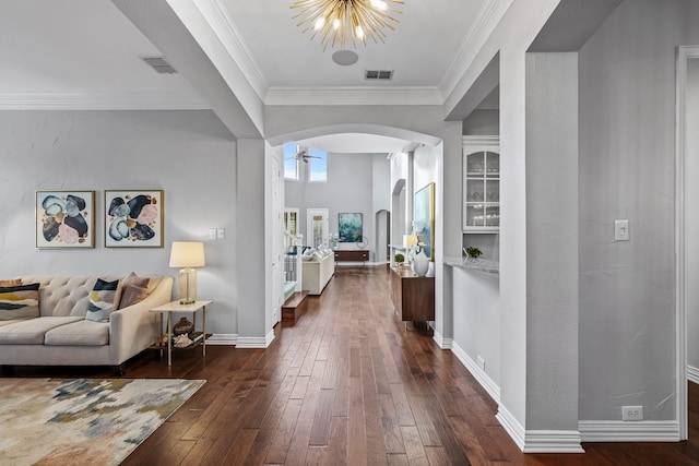 hall featuring dark hardwood / wood-style flooring, ornamental molding, and an inviting chandelier