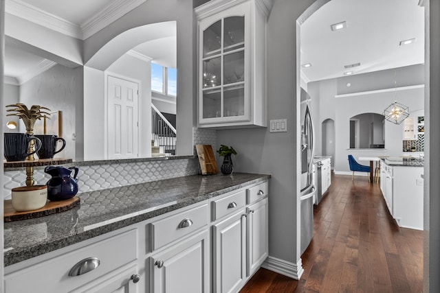 kitchen featuring white cabinets, decorative backsplash, dark stone counters, and dark hardwood / wood-style flooring