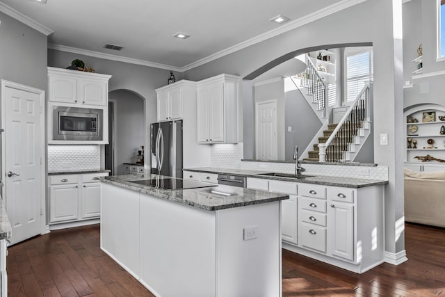 kitchen with white cabinets, dark hardwood / wood-style flooring, stainless steel appliances, tasteful backsplash, and sink