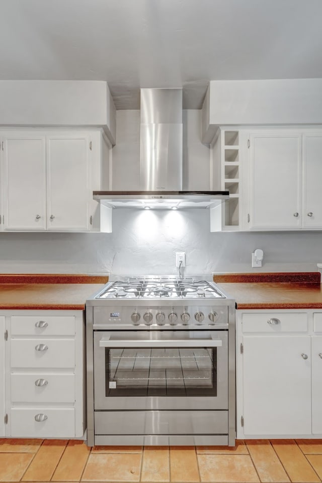 kitchen featuring wall chimney exhaust hood, white cabinetry, and high end stove