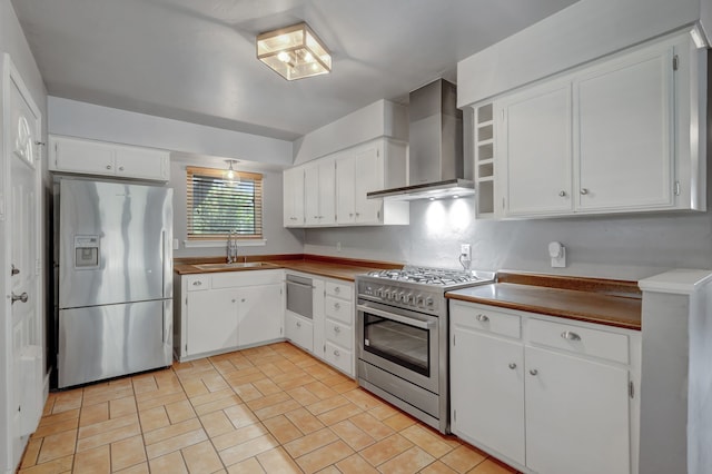 kitchen with wall chimney range hood, stainless steel appliances, white cabinets, and sink