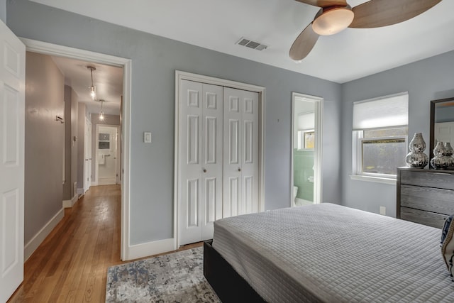 bedroom featuring light hardwood / wood-style floors, ensuite bathroom, a closet, and ceiling fan