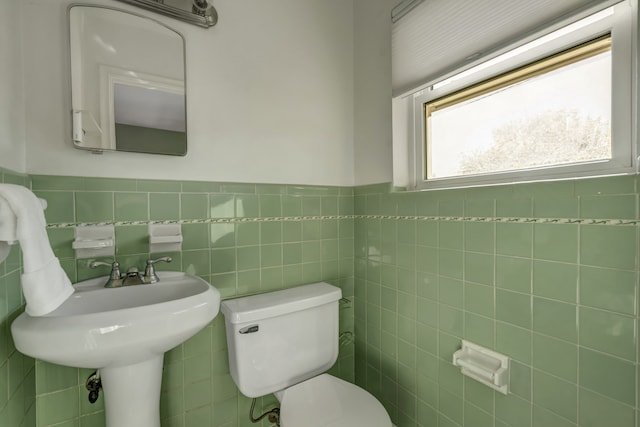 bathroom featuring toilet and tile walls