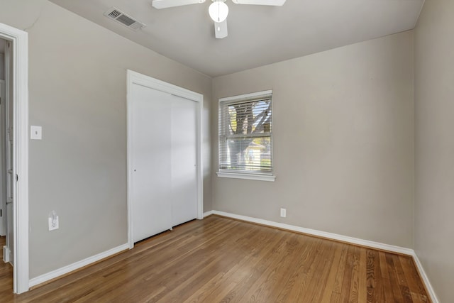 unfurnished bedroom with light hardwood / wood-style flooring, a closet, and ceiling fan