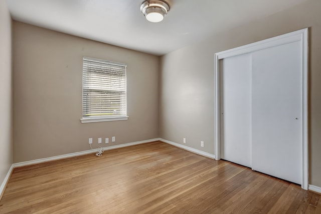 unfurnished bedroom featuring light hardwood / wood-style floors and a closet