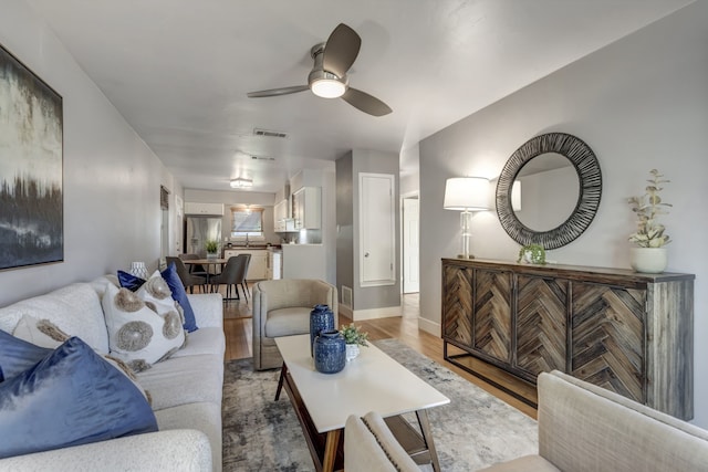 living room featuring ceiling fan and light hardwood / wood-style flooring