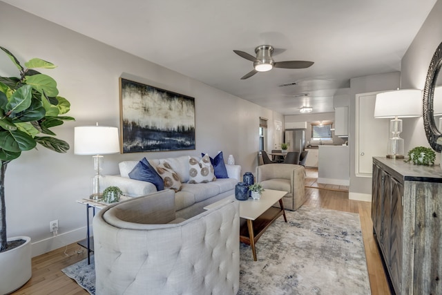 living room with light hardwood / wood-style floors and ceiling fan