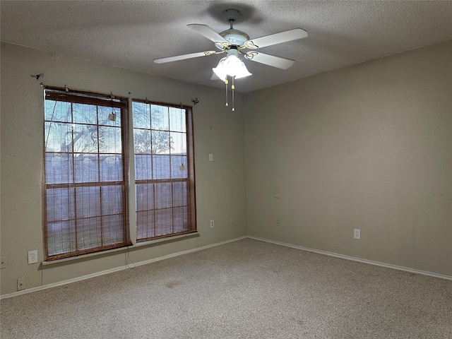 carpeted spare room with a textured ceiling and ceiling fan