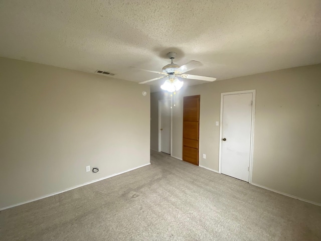 unfurnished bedroom with ceiling fan, carpet, and a textured ceiling