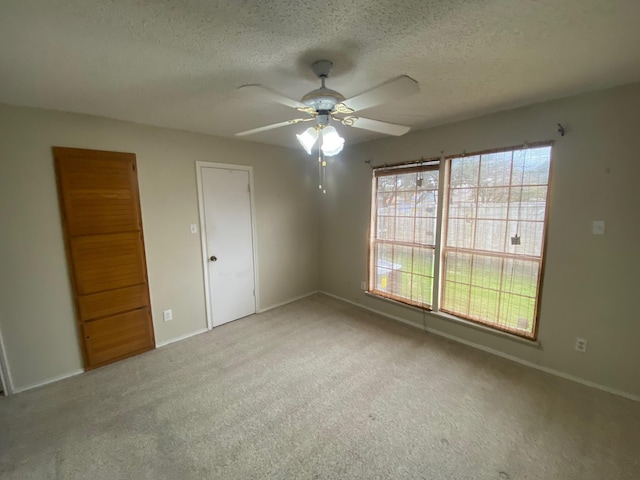 carpeted spare room with ceiling fan and a textured ceiling