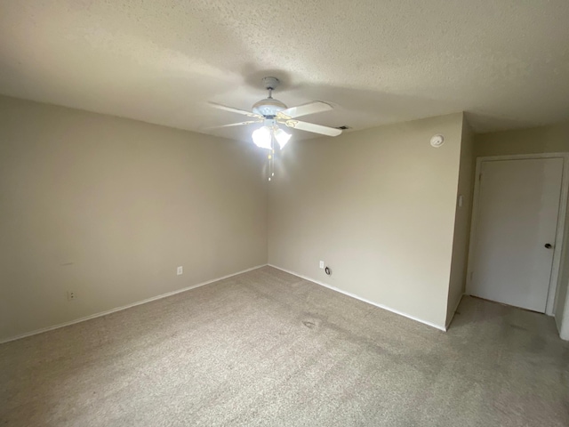 carpeted empty room with a textured ceiling and ceiling fan